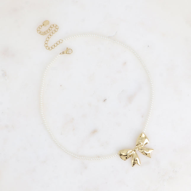 Collier sur câble Zénaïe - ras de cou, perles de résine blanche et pendentif noeud papillon