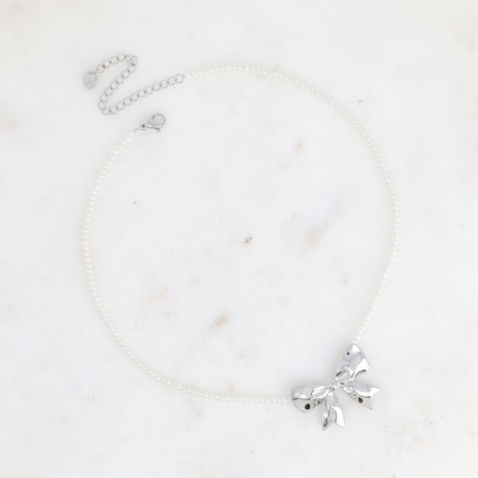Collier sur câble Zénaïe - ras de cou, perles de résine blanche et pendentif noeud papillon