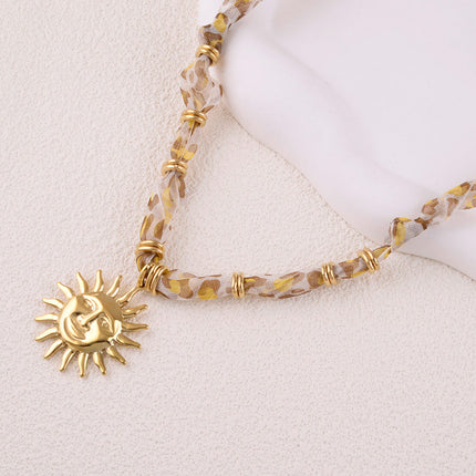 Collier Delphina - tissu, anneaux en acier et pendentif soleil souriant