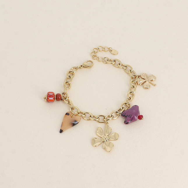 Bracelet - perles et oiseau en céramique, trèfle, coeur en résine et fleur