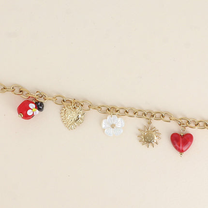 Bracelet - pendentifs (coccinelle en résine, scarabée, fleur nacrée, coeur, soleil)