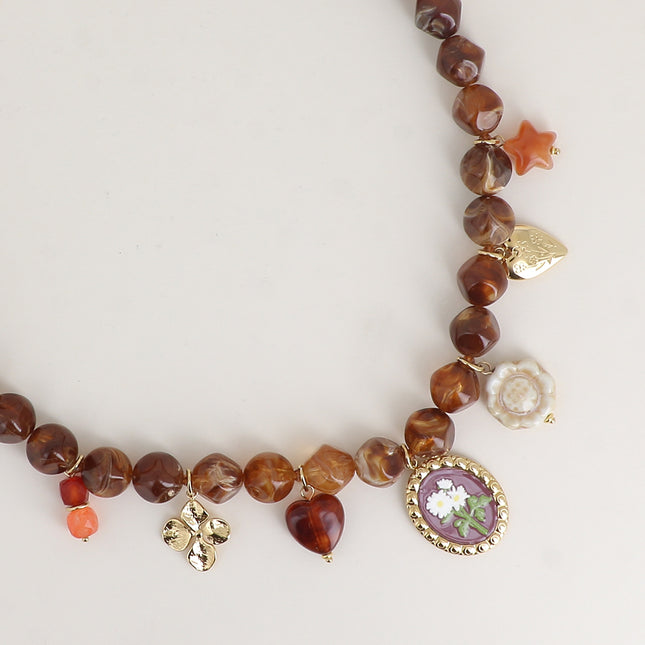 Collier - sur câble, perles en résine et de breloques (trèfle, fleurs, coeur, étoile en résine, perle céramique émaillée)