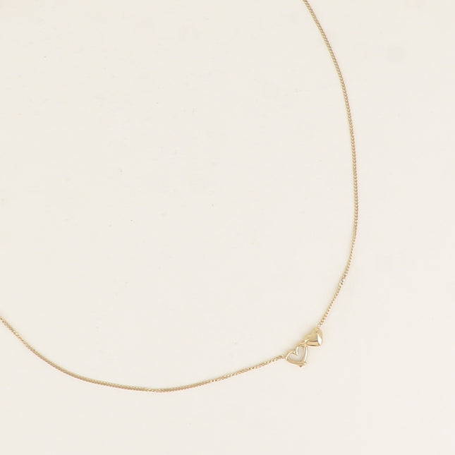 Collier - une fine maille gourmette et de deux coeurs