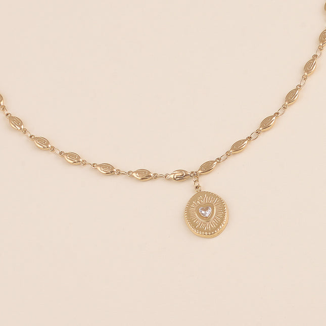 Collier - maillons coquilles et pendentif ovale texturé avec coeur en cristal