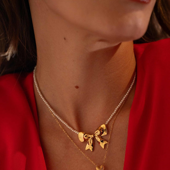 Collier sur câble Zénaïe - ras de cou, perles de résine blanche et pendentif noeud papillon
